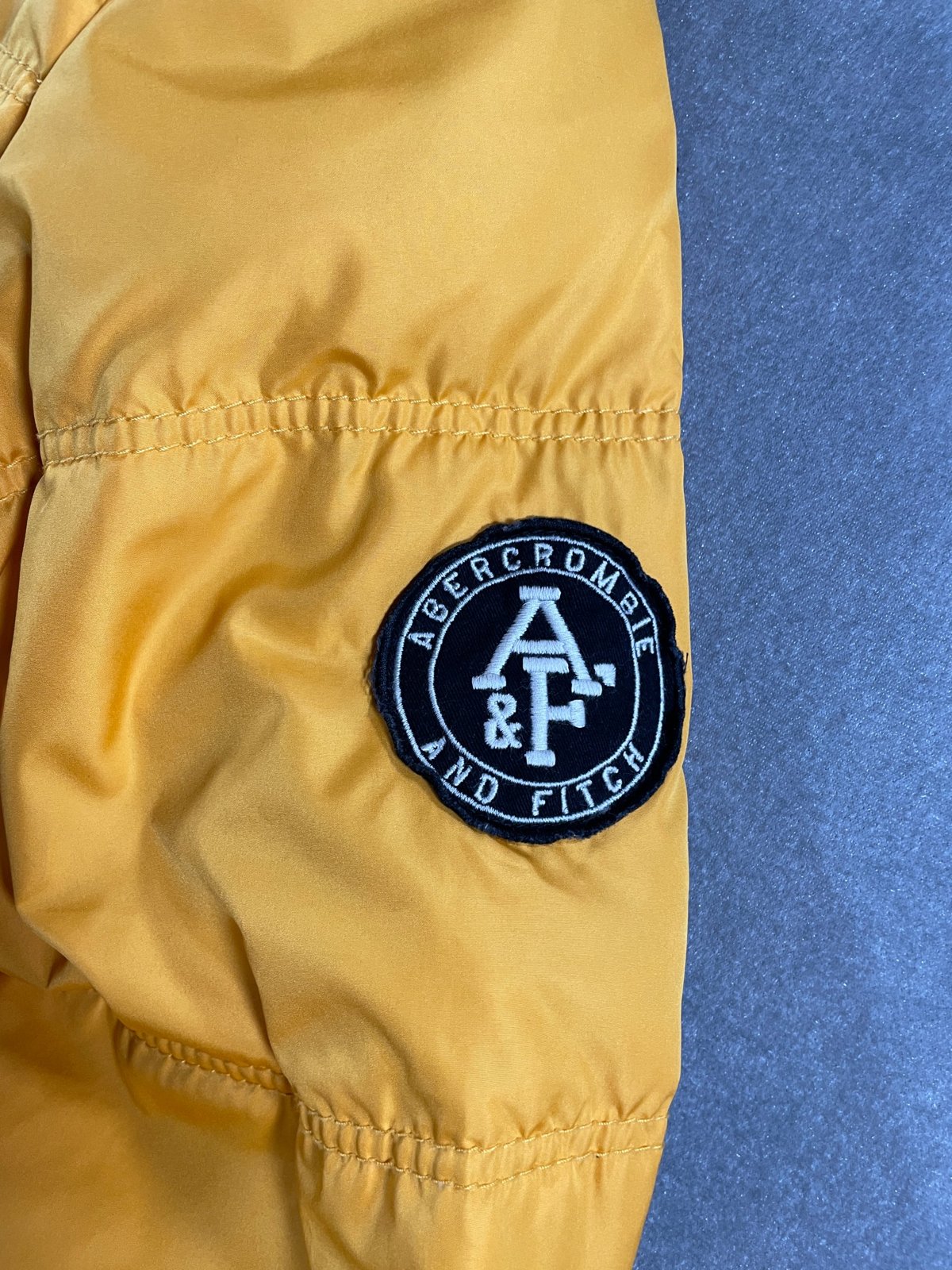 左袖の丸いワッペン「ABERCROMBIE AND FITCH」A&F